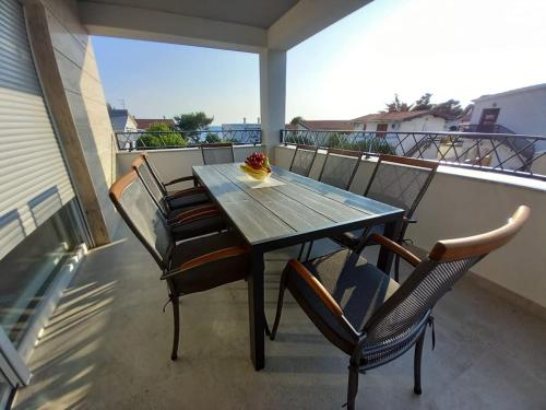 a wooden table and chairs on a balcony at Apartment ValMar in Vir
