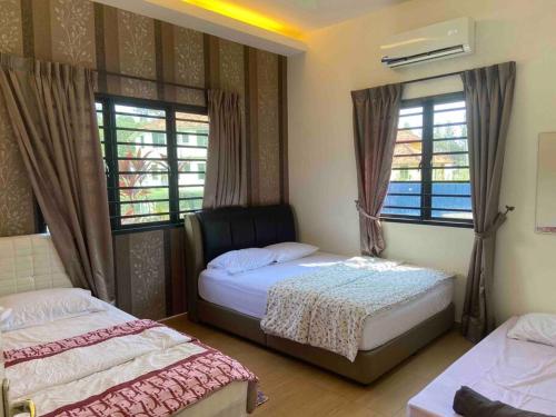 1 dormitorio con 2 camas y 2 ventanas en Melaka Beach Villa en Melaka
