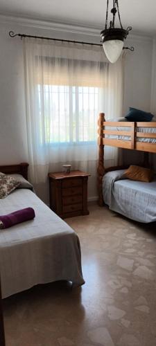 Un dormitorio con dos camas y una ventana. en Casas del Madroño, en Cazalla de la Sierra