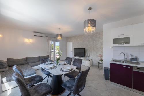 a kitchen and a living room with a table and chairs at Treno, Luxurious Apartment with Jacuzzi and Sea-View in Trogir