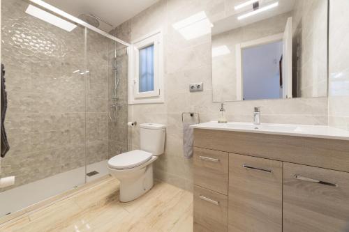 uma casa de banho com um WC, um chuveiro e um lavatório. em SILOM HOUSE em Sant Pere de Ribes