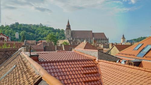 een uitzicht op de daken van een stad met een klokkentoren bij Comfort Apartment Rooftop Brasov in Braşov