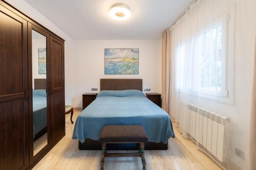 um quarto com uma cama, uma cadeira e uma janela em SILOM HOUSE em Sant Pere de Ribes