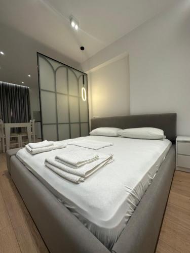 a bedroom with a large white bed with towels on it at Center Apartment in Tirana