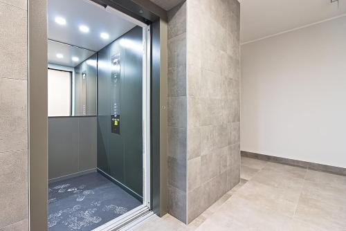 uma cabina de duche ao nível do chão com uma porta de vidro em Varsovia Residence apartament 17 Parking em Elblag