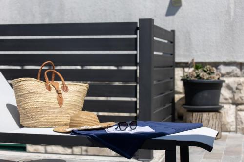a pair of glasses and a hat sitting on a bench at Treno, Luxurious Apartment with Jacuzzi and Sea-View in Trogir