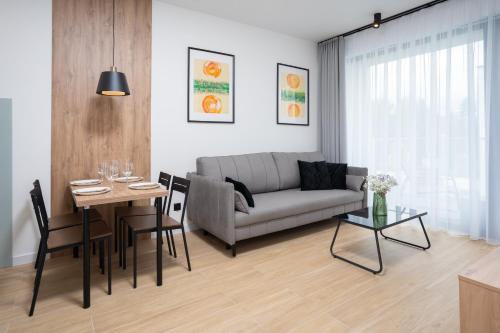 a living room with a couch and a table at Apartamenty Olimpijska by RENT4YOU in Olsztyn