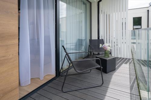 a balcony with a chair and a table at Apartamenty Olimpijska by RENT4YOU in Olsztyn