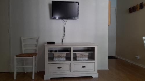 een witte kast met een televisie aan de muur bij Appartement T2 hyper centre Luchon in Luchon