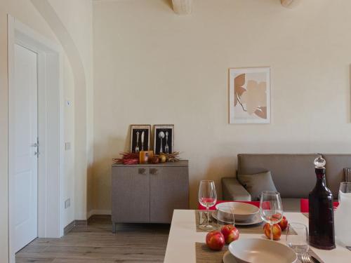 Modern Apartment in Agliana with Shared Garden في Agliana: غرفة معيشة مع طاولة مع كؤوس للنبيذ وأريكة