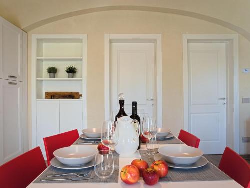 Modern Apartment in Agliana with Shared Garden في Agliana: طاولة عليها زجاجتين من النبيذ والفواكه