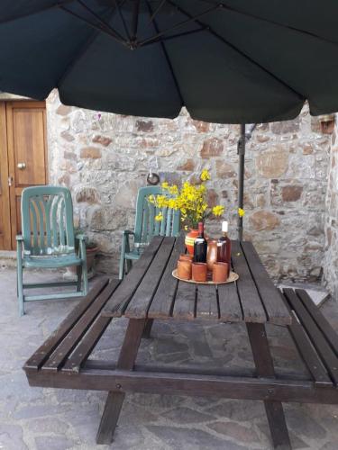 a picnic table with two chairs and an umbrella at Querciagrossa da Dora in Roccastrada