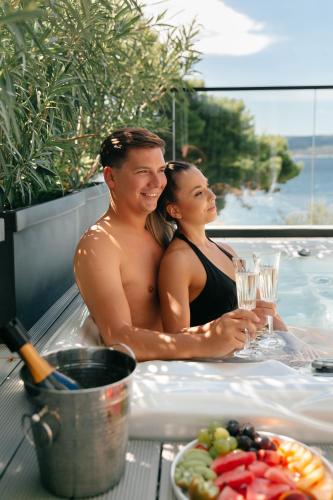 a man and a woman sitting in a hot tub at Hotel Medistone in Omiš