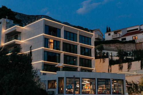 a large white building with lights on it at Hotel Medistone in Omiš