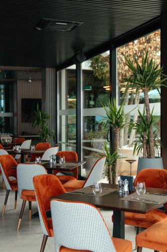 a restaurant with tables and chairs and windows at Hotel Medistone in Omiš