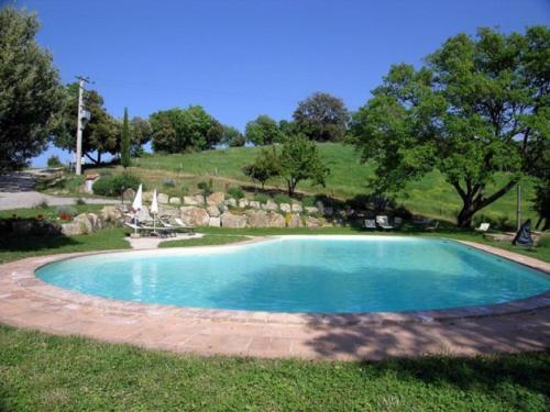 ein großer blauer Pool im Gras in der Unterkunft Pleasant holiday home in Seggiano with private terrace in Seggiano