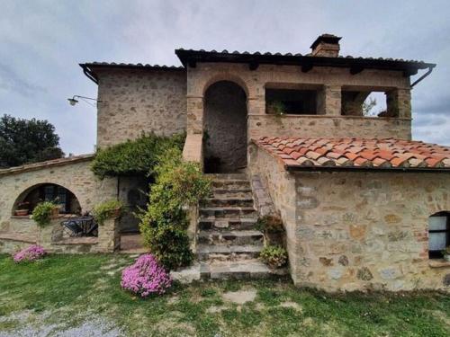 una antigua casa de piedra con escaleras en el patio en Pleasant holiday home in Seggiano with private terrace, en Seggiano