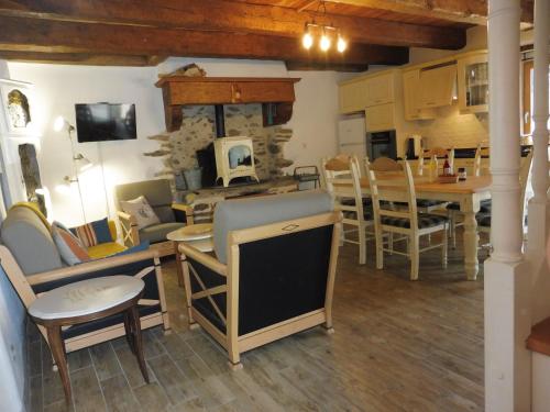 une cuisine et une salle à manger avec une table et des chaises dans l'établissement Gîtes du Guébriand, à Saint-Lormel