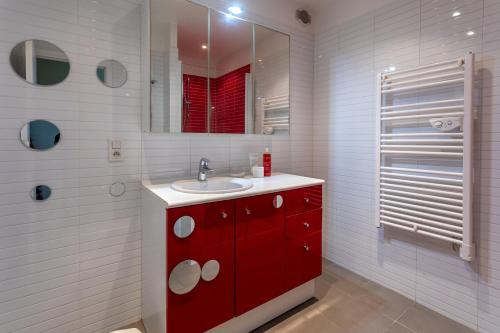 a bathroom with a red sink and a mirror at Le Plein Sud Terrasse vue mer Agay in Saint-Raphaël