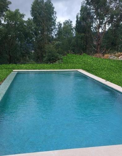 a large blue swimming pool in a field of grass at Villa SobreDouro in Sardoeira