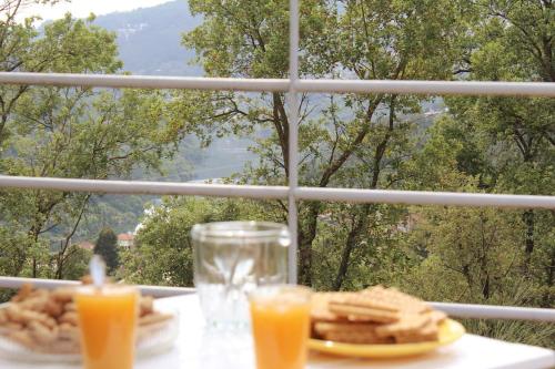 a table with a plate of crackers and orange juice at Villa SobreDouro in Sardoeira