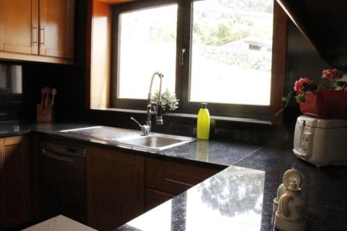 a kitchen with a sink and a window at Villa SobreDouro in Sardoeira