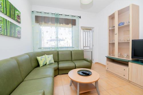 een woonkamer met een groene bank en een tafel bij Casinha I by Innkeeper in Guia