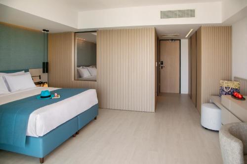 a hotel room with a bed and a chair at Mercure Larnaca Beach Resort in Larnaka