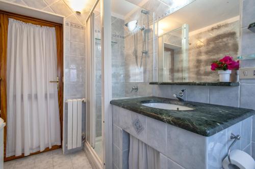 a bathroom with a sink and a shower at Casetta Brandinu in Sassari