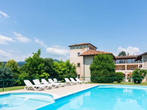 einen Pool mit Liegestühlen und ein Gebäude in der Unterkunft Modern Apartment in Sal with Swimming Pool in Salò