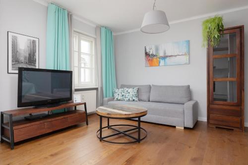 a living room with a television and a couch at City Center Aparthotel Chmielna by Renters in Warsaw