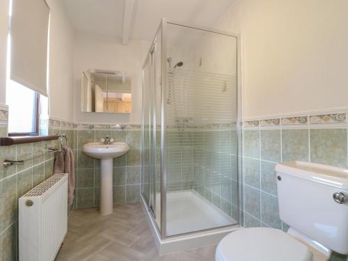 uma casa de banho com um chuveiro, um WC e um lavatório. em 27 Brocklehurst em Oakham