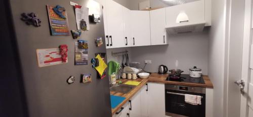 una pequeña cocina con armarios blancos y fregadero en Nowy 1 z 2 pokoi w mieszkaniu w Ursusie, en Varsovia