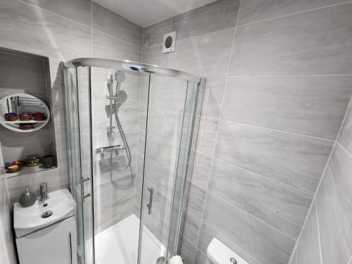 y baño con ducha, aseo y lavamanos. en Cosy Studio Wembley Stadium Gem, en Wembley