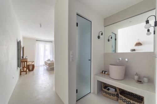 La salle de bains blanche est pourvue d'un lavabo et d'un miroir. dans l'établissement Andros Utopia, à Batsi