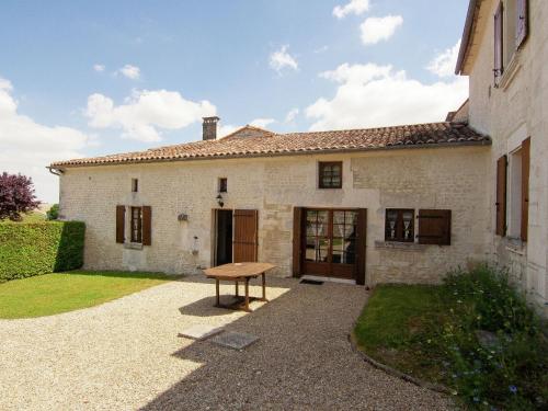 a house with a picnic table in front of it at Luxury apartment with terrace sauna tennis pool in Saint-Preuil