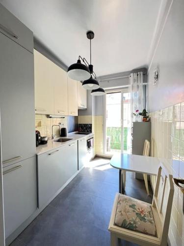 une cuisine avec des armoires blanches et une table à l'intérieur dans l'établissement Charming Flat in heart of Nice, à Nice