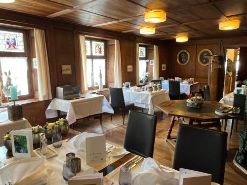 a restaurant with white tables and chairs and windows at Hotel Krone Sihlbrugg in Sihlbrugg Dorf