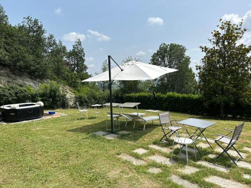 a group of tables and chairs with an umbrella at Bellaveduta Holidays Home in Baldissero Torinese