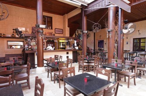 a restaurant with tables and chairs and a bar at Cicerone Lodge Hotel in Antalya