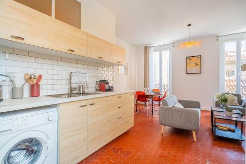 une cuisine avec une machine à laver et une table dans l'établissement Elana - Bel appartement dans la quartier du Camas, à Marseille