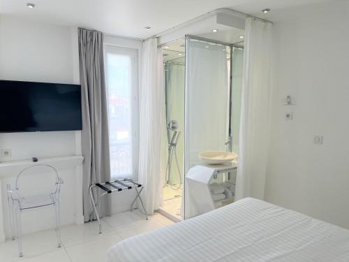 a white bedroom with a bed and a bathroom at Blc Design Hotel in Paris