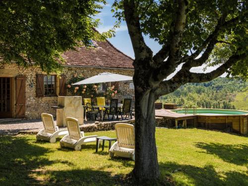 a tree with chairs and a table and a pool table at Farmhouse with private pool large garden and playground in Thenon