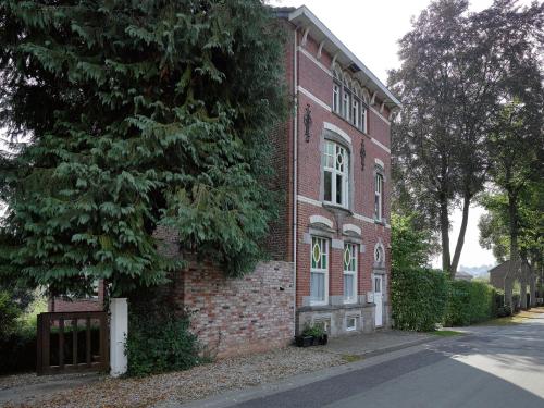 a brick building with a tree next to a street at Suave Holiday Home in Stavelot with Infrared Sauna in Stavelot