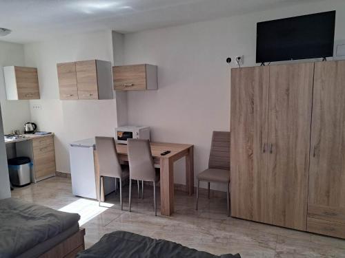 Habitación con mesa, sillas y cocina. en Penzion FRENAT, en Kúty