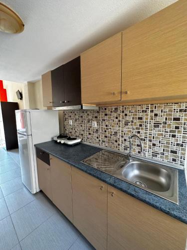 a kitchen with a sink and a refrigerator at Rooms Elena in Nea Potidaea