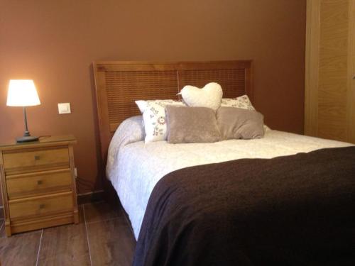 a bedroom with a bed and a night stand with a lamp at La plazuela Navaluenga in Navaluenga