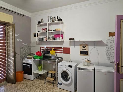 ヴィッラッジョ・モセにあるPiccoledonneの洗濯機と洗濯機付きのランドリールーム