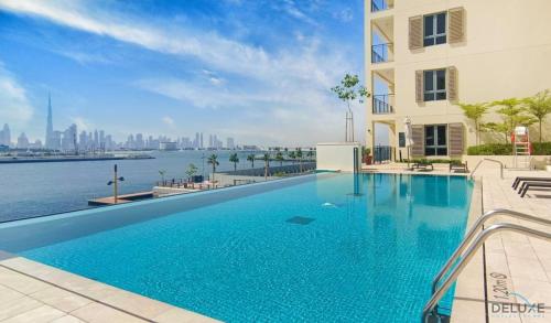 a swimming pool in a building with a view of the water at Peaceful 4BR Penthouse with Assistant Room at Le Pont Jumeirah by Deluxe Holiday Homes in Dubai