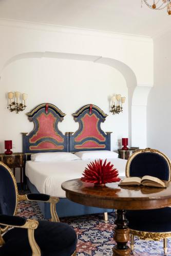 a bedroom with a bed and a table with chairs at Villa De Cillis Carafa in Torre del Greco
